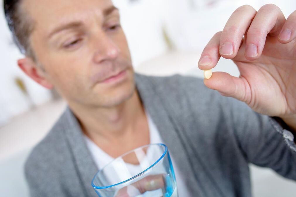 muž pije pilulku, aby zvýšil účinnost